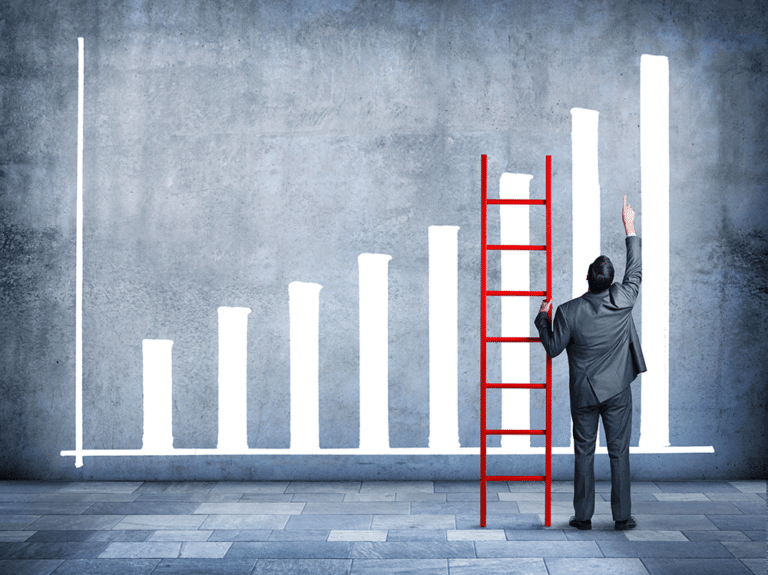 A man in a suit points at a drawn bar graph with increasing bars. A red ladder leans against the graph on a gray background.