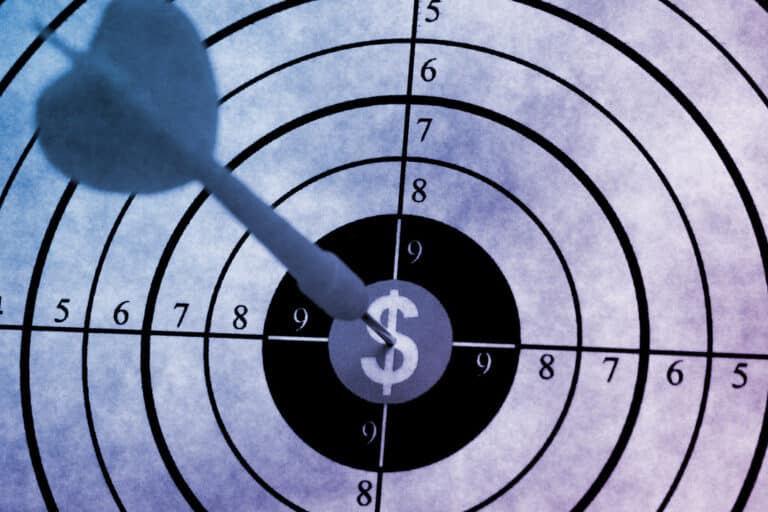 A dart hits the bullseye on a target with a dollar sign at the center, symbolizing financial success.