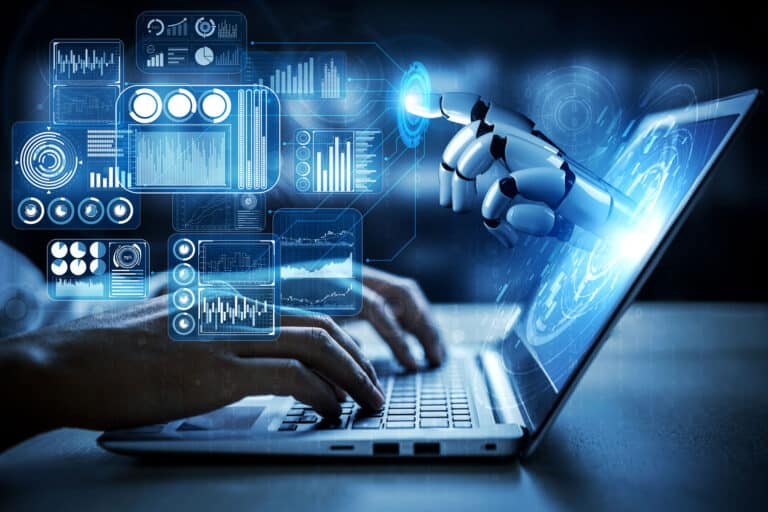 A human typing on a laptop with a robotic hand touching a digital interface displaying futuristic data graphs and charts.