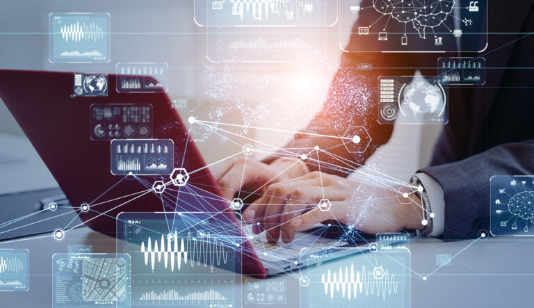 Person typing on a laptop with digital data and graphs overlay, symbolizing technology and data analysis.