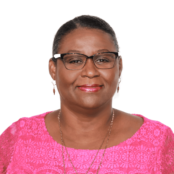 A person wearing glasses and a pink lace-patterned top, smiling at the camera against a white background.