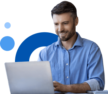 A man in a blue shirt is smiling while using a laptop, with abstract blue shapes in the background.