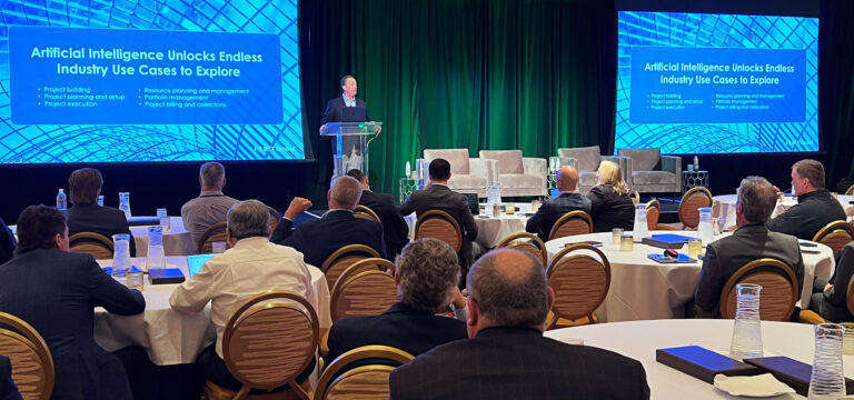 A presentation on artificial intelligence takes place at a conference. The speaker stands at a podium, and attendees sit at round tables. Two large screens display related information.